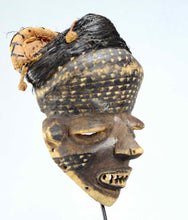 Masque Pende traditionnel, vue diagonale, fibres végétales et pigments.